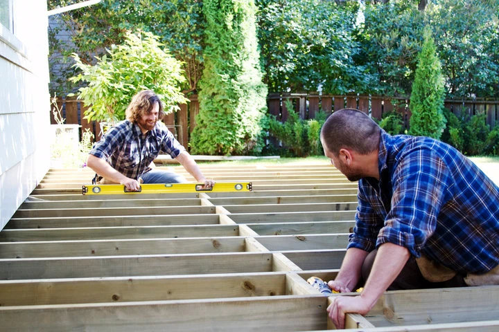 Deck builders reinforcing the structural framework of a residential custom deck in Allentown